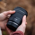 Lente Canon RF 24-105mm f/4-7.1 IS STM sostenido en la mano para mostrar su tamaño